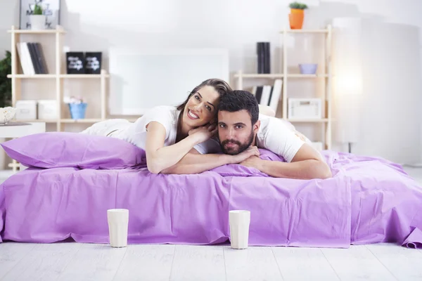 Feliz jovem casal na cama sofá no quarto ded — Fotografia de Stock