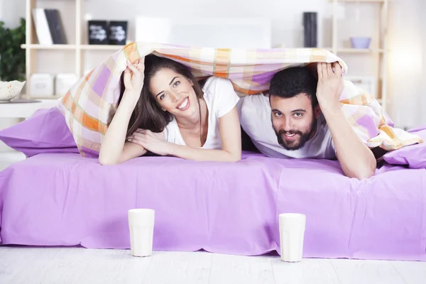 Feliz joven pareja en la cama sofá en habitación ded —  Fotos de Stock