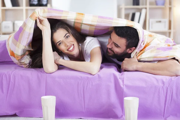 Feliz jovem casal na cama sofá no quarto ded — Fotografia de Stock
