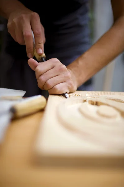 Hout snijwerk op tafel met kunstenaar — Stockfoto