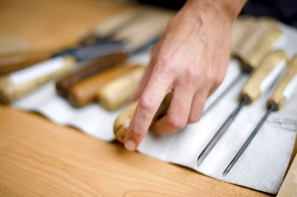 Wood carving on table with artist — Stock Photo, Image