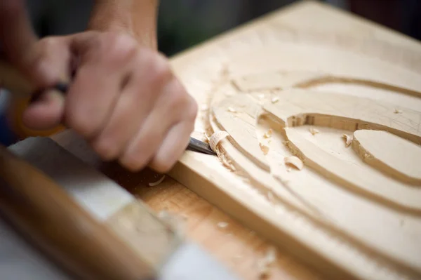 Holzschnitzerei auf dem Tisch mit Künstler — Stockfoto