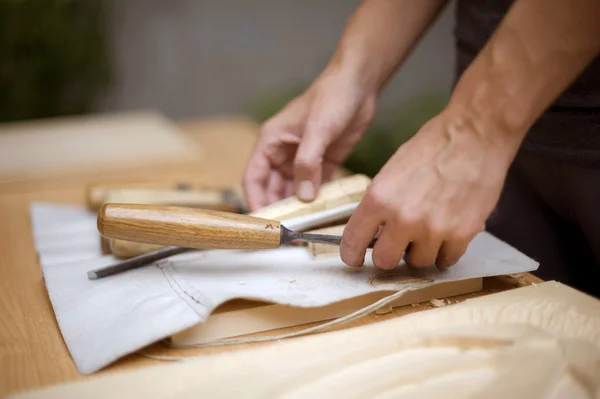 Hout snijwerk op tafel met kunstenaar — Stockfoto