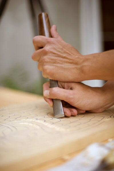 Wood carving on table with artist