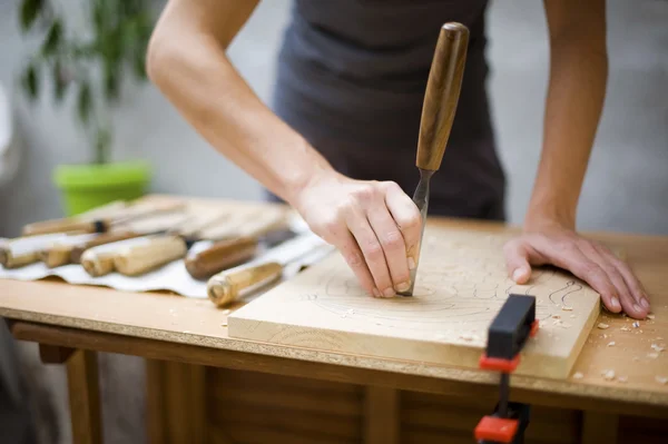 Wood carving on table with artist — Stock Photo, Image