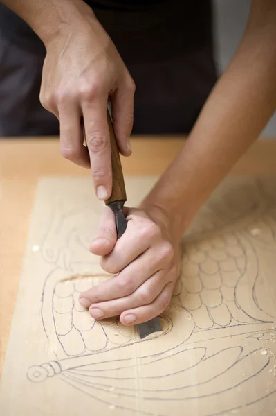 Hout snijwerk op tafel met kunstenaar — Stockfoto