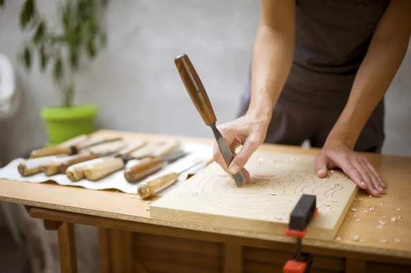 Wood carving på bord med konstnären — Stockfoto