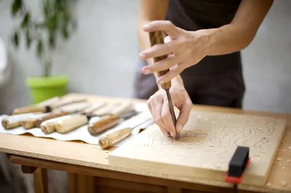 Wood carving on table with artist — Stock Photo, Image