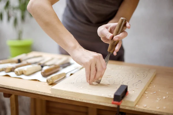 Wood carving på bord med konstnären — Stockfoto