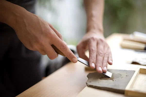 Hout snijwerk op tafel met kunstenaar — Stockfoto