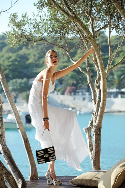 Menina bonita em um vestido branco na plataforma de madeira — Fotografia de Stock