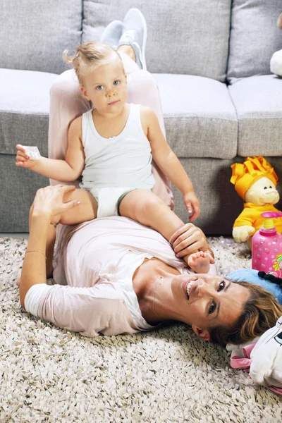 Mother playing with daughter in livingroom — Stock Photo, Image