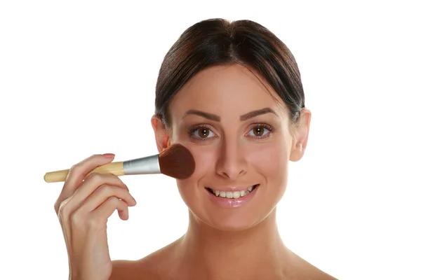 Mujer sosteniendo cepillo rubor y aplicando maquillaje — Foto de Stock