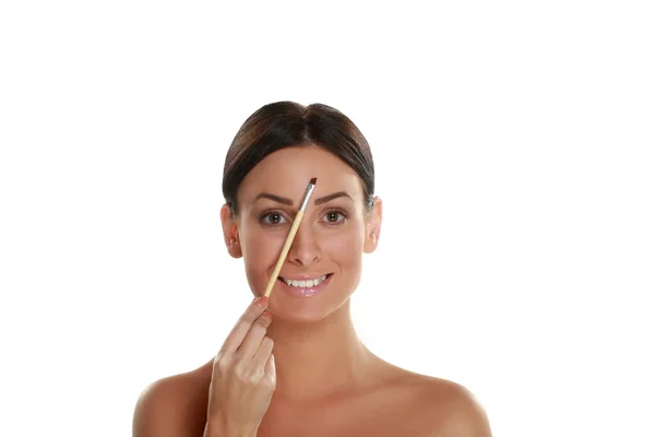 Woman holding blush brush and applying make-up — Stock Photo, Image