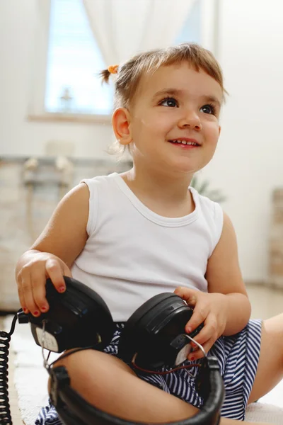 Lilla flickan ler och spelar i vardagsrummet — Stockfoto