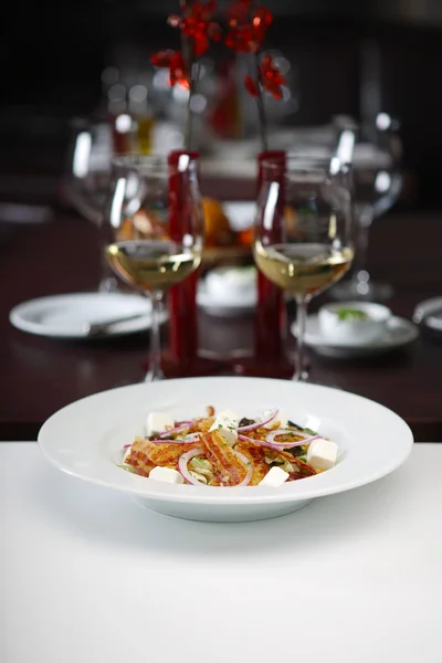 Delicious salad with wine glasses — Stock Photo, Image