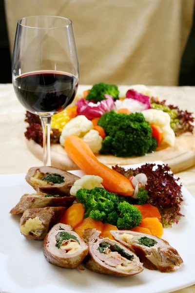 Свинина с овощами и бокалом вина — стоковое фото