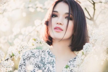 Kiraz sakura çiçekleri arasında güzel Asyalı kız portresi