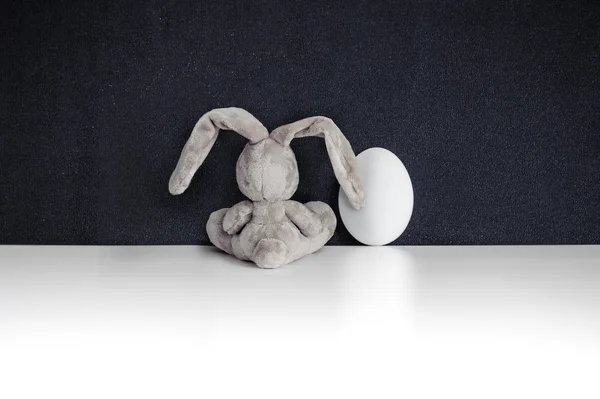 Conejo conejo con huevo de Pascua en el fondo de la pizarra — Foto de Stock