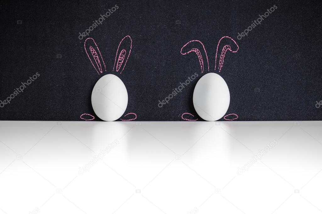 Two white easter eggs on a chackboard