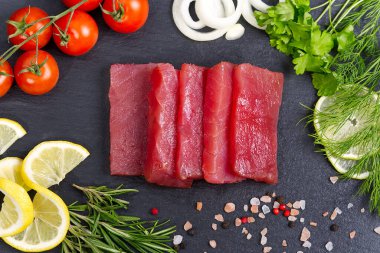 Mutfakta çiğ ton balığı dilimi ve otlarla süslenmiş.