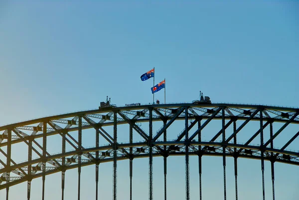 風に吹かれながら2本のオーストラリア国旗と シドニー港の橋の上の景色を楽しむ人々ニューサウスウェールズ州 オーストラリア — ストック写真