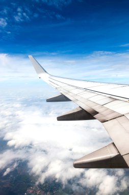 arka planda uçan uçak kanadı bulutlar,