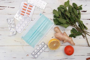 Tahta bir masada meyve ve haplar. Haplar ve meyveler arasında seçim yap. Tedavi, geleneksel tıp. Taze meyve haplara karşı. Meyvelerdeki doğal vitamin haplardaki sentetik vitamine karşı. Doğal ve sentetik arasında seçim 