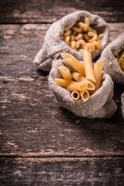 Makarna ahşap rustik arka plan üzerine çeşitli karışımı. Beslenme ve gıda 