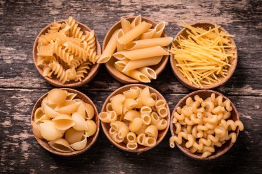 Makarna ahşap rustik arka plan üzerine çeşitli karışımı. Beslenme ve gıda 