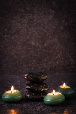 ahşap masa üzerinde taş ve mumlar ile spa konsepti ,