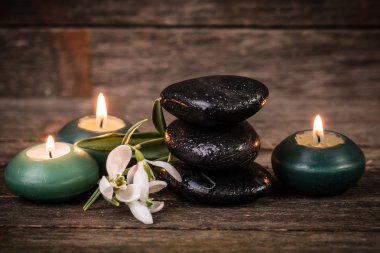 ahşap masa üzerinde taş ve mumlar ile spa konsepti ,