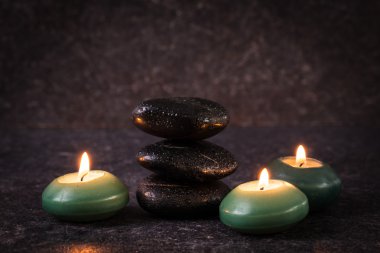 ahşap masa üzerinde taş ve mumlar ile spa konsepti ,