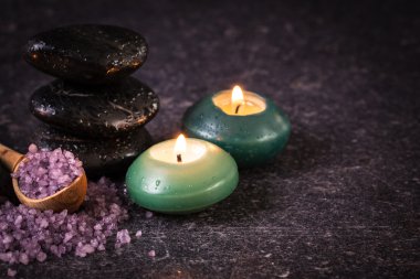 ahşap masa üzerinde taş ve mumlar ile spa konsepti ,