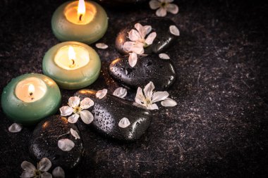ahşap masa üzerinde taş ve mumlar ile spa konsepti ,