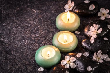 ahşap masa üzerinde taş ve mumlar ile spa konsepti ,
