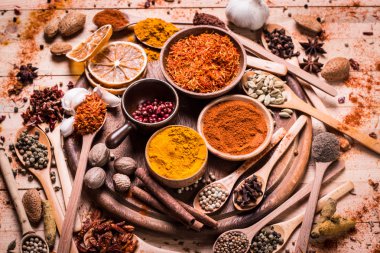 Ahşap masada baharatlar ve otlar.