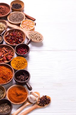 Ahşap masada baharatlar ve otlar.