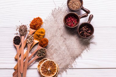 Ahşap masada baharatlar ve otlar.
