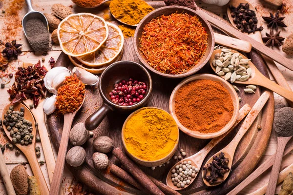 Ahşap masada baharatlar ve otlar.