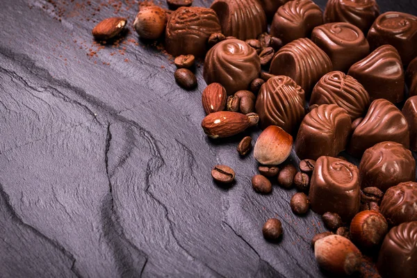 Deliciosos caramelos de chocolate sobre fondo de madera — Foto de Stock