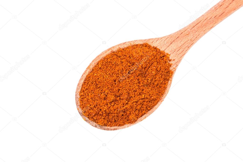 Powdered dried red pepper on a wooden spoon isolated