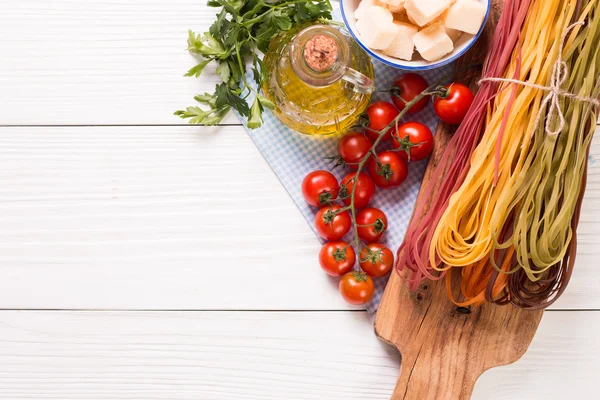 Vegetable color Pasta, oil,tomatoes,cheese on wooden table. italian food