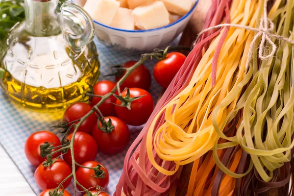 Colore vegetale Pasta, olio, pomodori, formaggio sul tavolo di legno. cibo italiano — Foto Stock