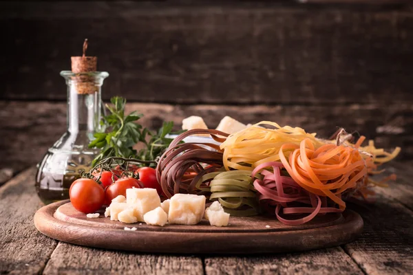 Vegetable color Pasta, oil,tomatoes,cheese on wooden table. italian food — Stock Photo, Image