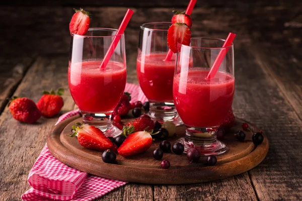 Vasos de batido frío fresco con frutas y bayas, sobre fondo de madera, bebida desintoxicante saludable —  Fotos de Stock