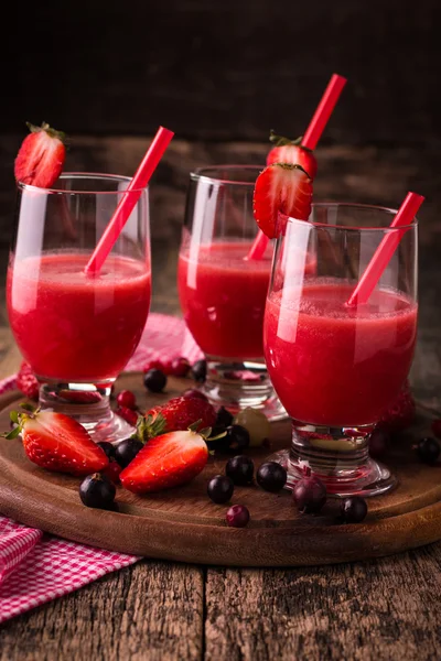 Copos de smoothie frio fresco com frutas e bagas, em fundo de madeira, bebida de desintoxicação saudável — Fotografia de Stock