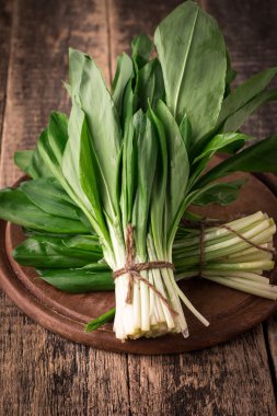 Bahar ramson veya yabani pırasa ot taze hasat grup vintage ahşap masa arka plan üzerinde bırakır.