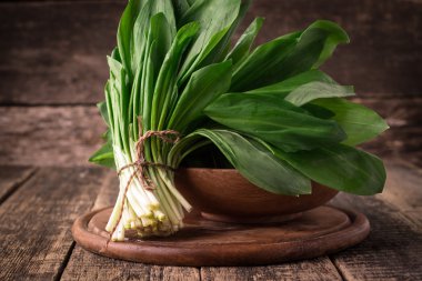 Bahar ramson veya yabani pırasa ot taze hasat grup vintage ahşap masa arka plan üzerinde bırakır.