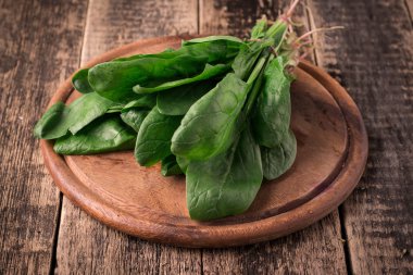 Bir avuç taze ıspanak kökleri eski ahşap yüzey üzerinde. Karanlık rustik tarzı